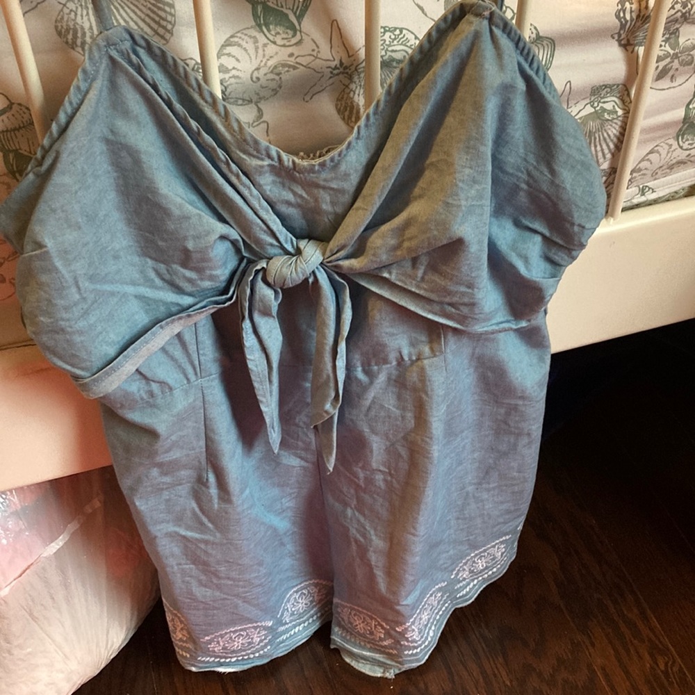 A blue jumpsuit with a design on the bottom